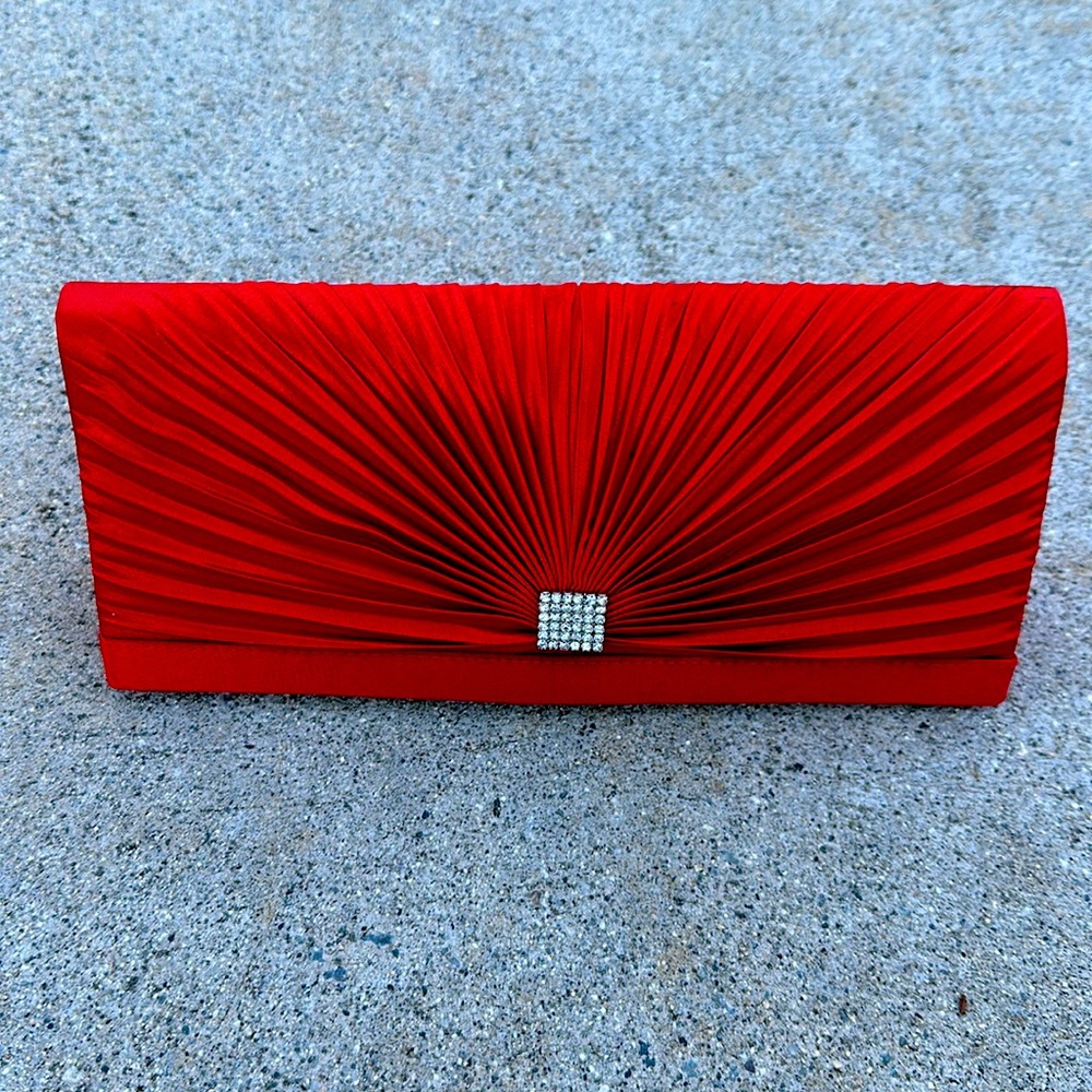 Red satin clutch with several straps for hand held or shoulder.